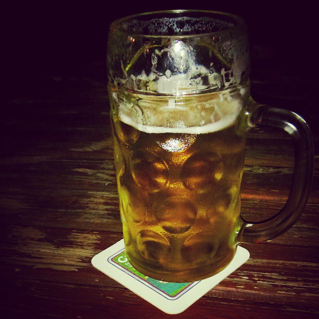 a mug of beer sitting on top of a table
