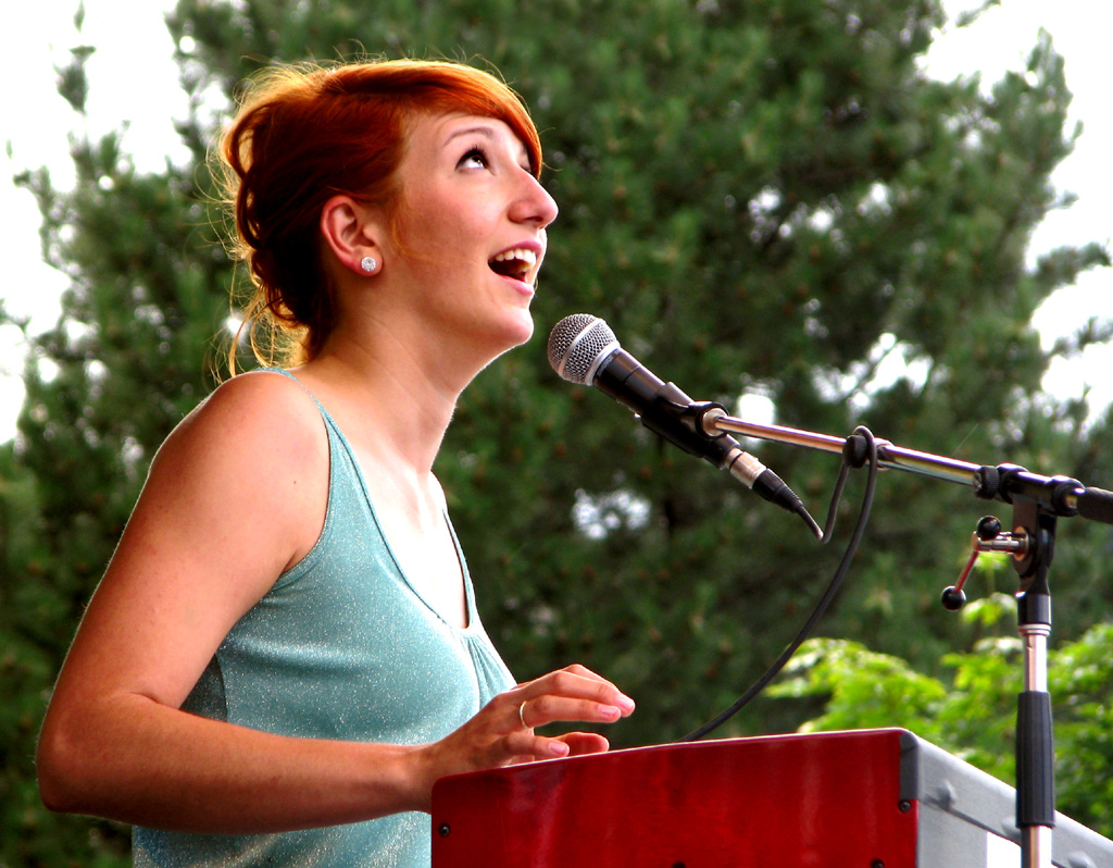 a woman with red hair speaking at a podium