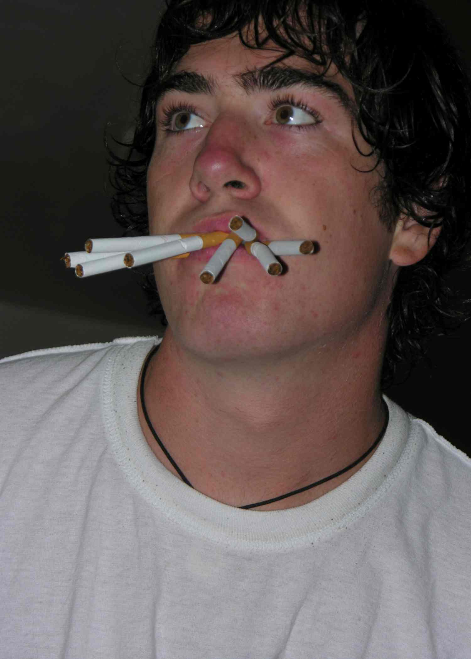 a man is using a cigarette in his mouth