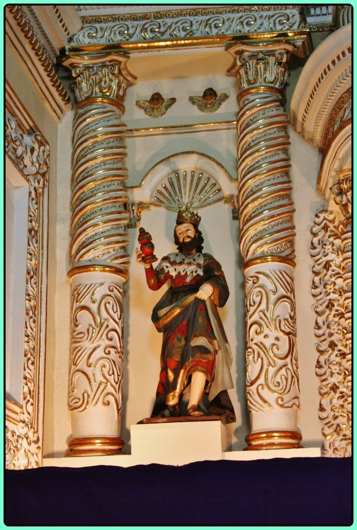 a statue with a gold crown and elaborate gold detailing