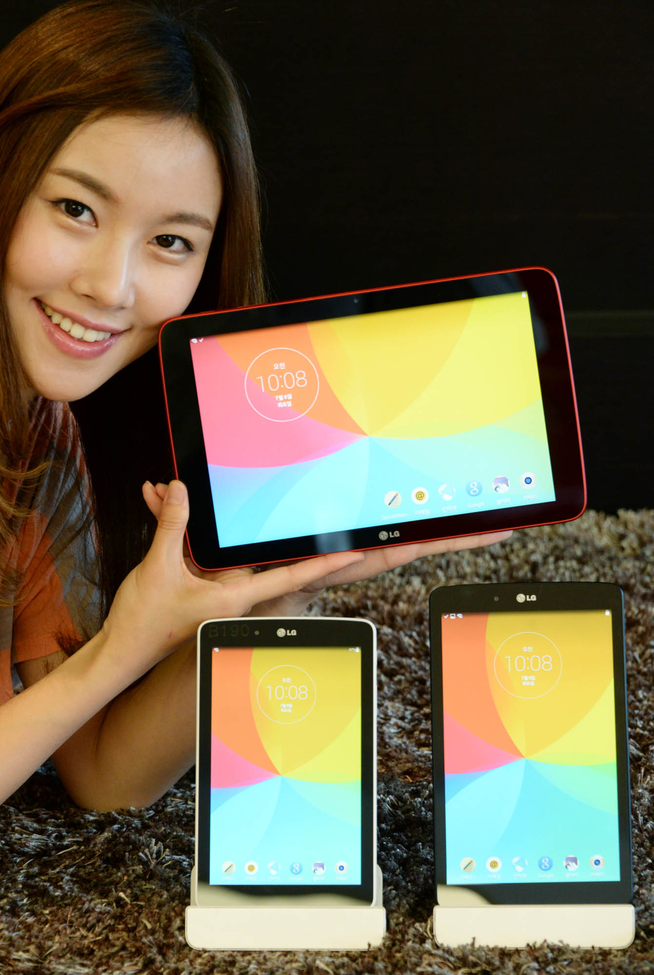 a girl holding a tablet next to two other devices