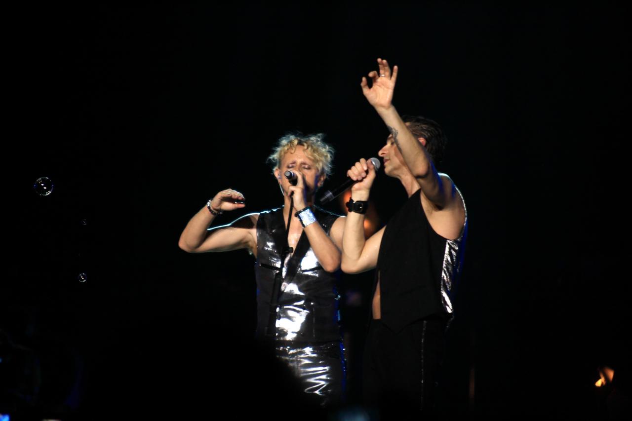 a couple of people on stage with arms in the air