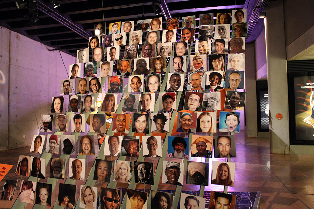 several pictures of faces are displayed in front of a display