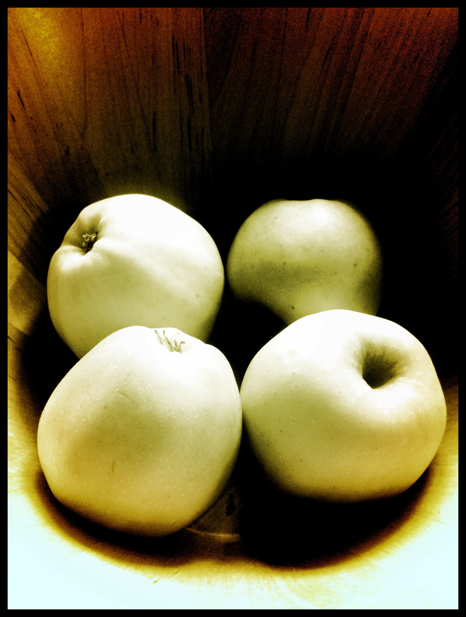 there are four apples sitting in a bowl