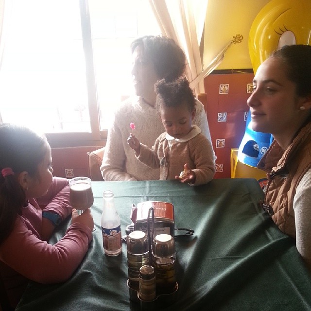 five adults sitting around a table with two young children