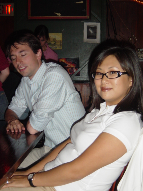 a woman wearing a white dress shirt sitting next to a man