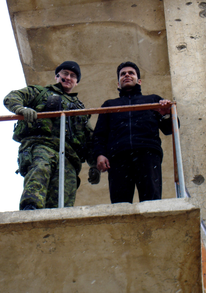 two soldiers standing by a guard rail, in the snow
