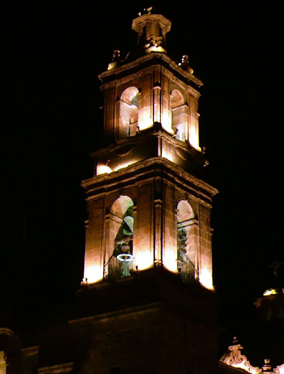 a tall tower is lit up at night