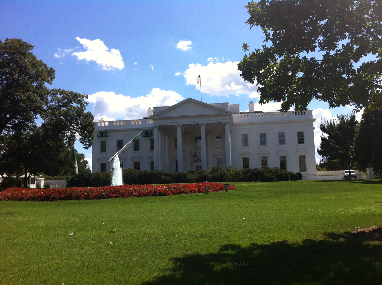 a large white building in the middle of the green lawn