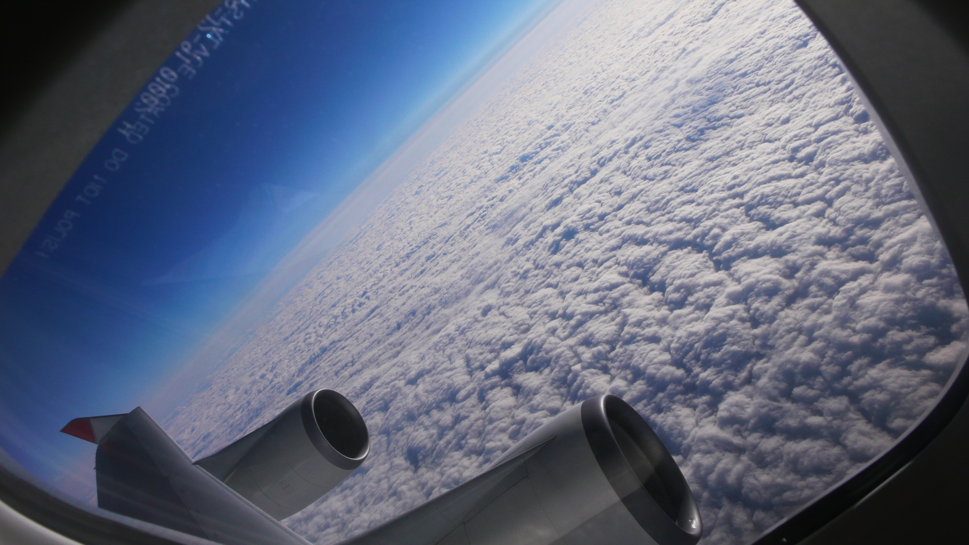 a view out of a window of some clouds and the wing