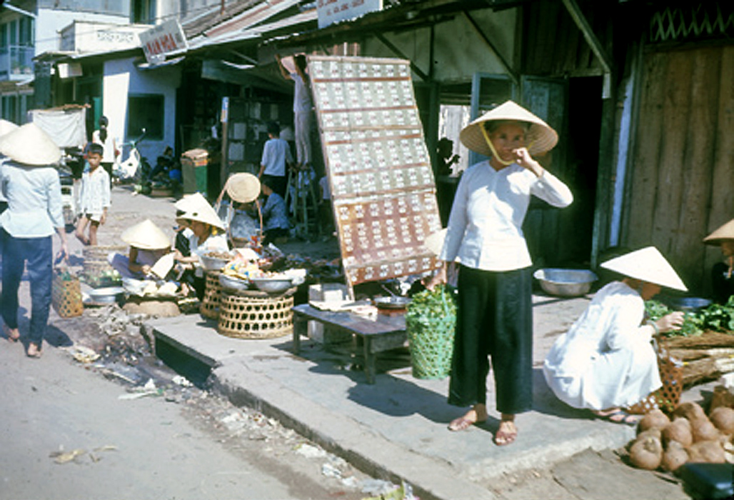 people are standing on the street while eating and shopping