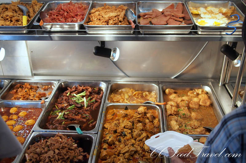 a buffet line of different food items in large trays