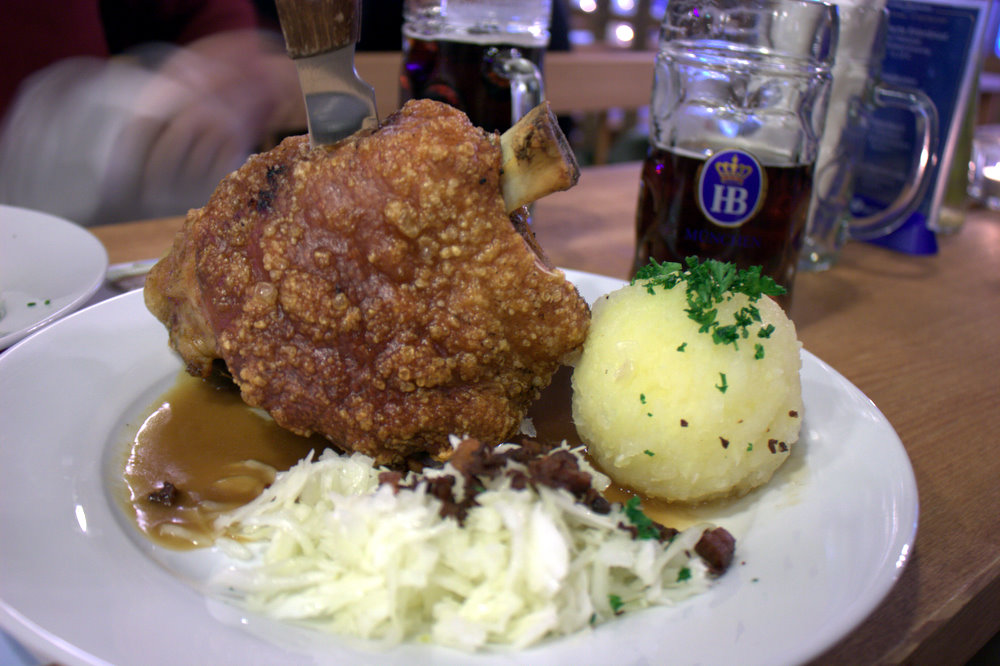 some meat and potatoes and beer on a plate