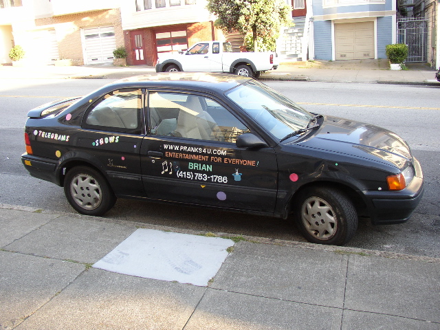 black car with a multicolored advertit on it on the street