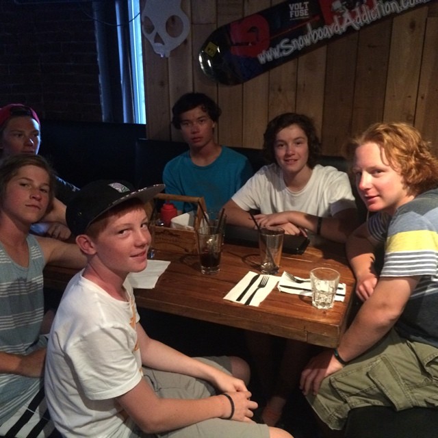 a group of friends sit around a table drinking beverages