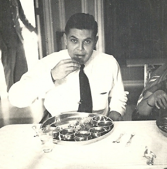 a man in a tie eating at a table
