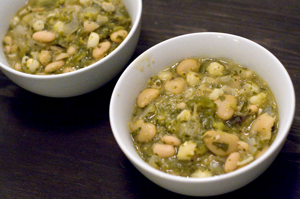 two bowls filled with beans and green sauce