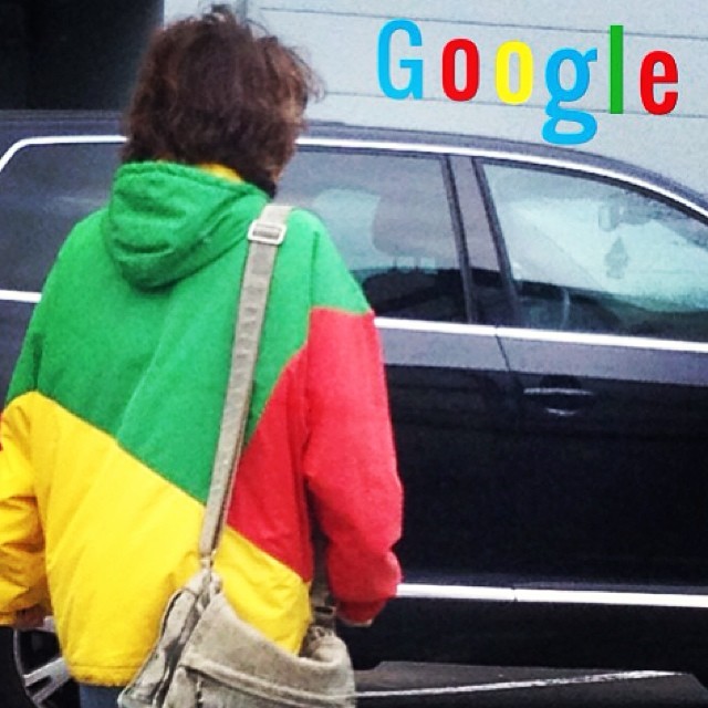 a man in a colorful jacket walking near a car