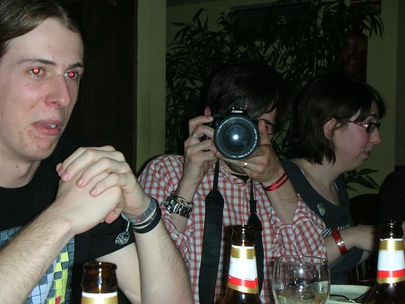 two people with cameras in front of some empty beer bottles