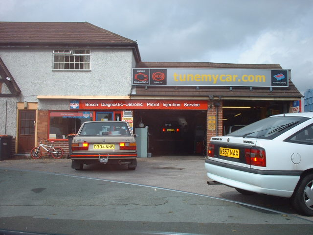 a truck parked next to a motorcycle repair shop