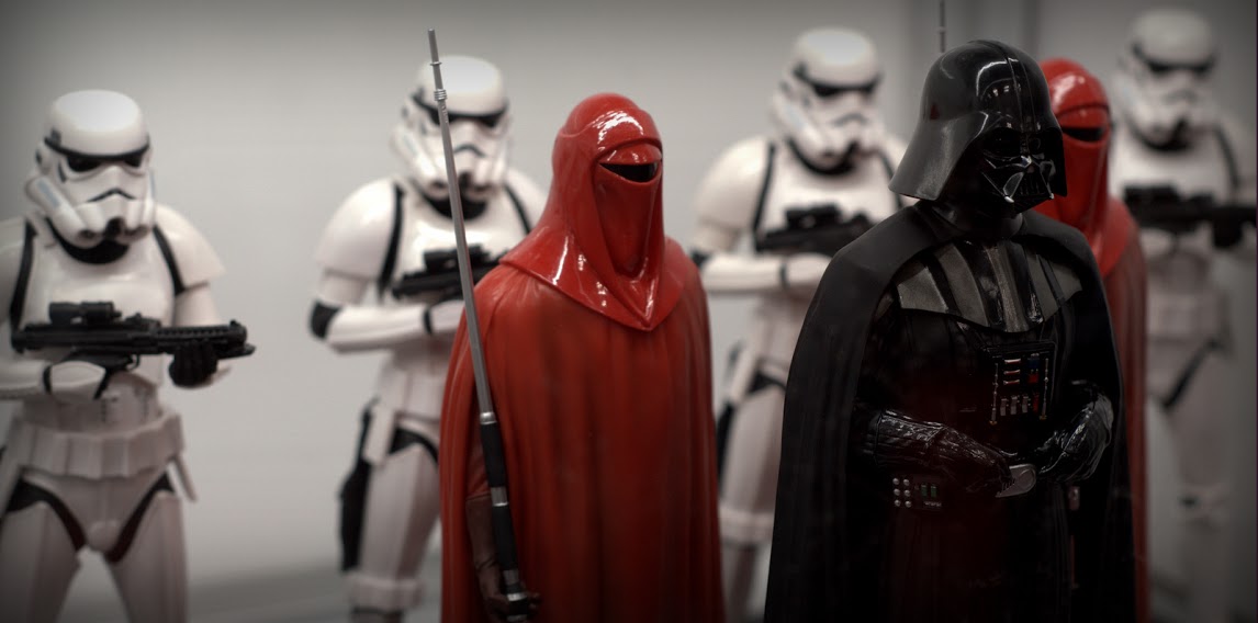 a row of star wars action figures, all wearing helmets and holding swords