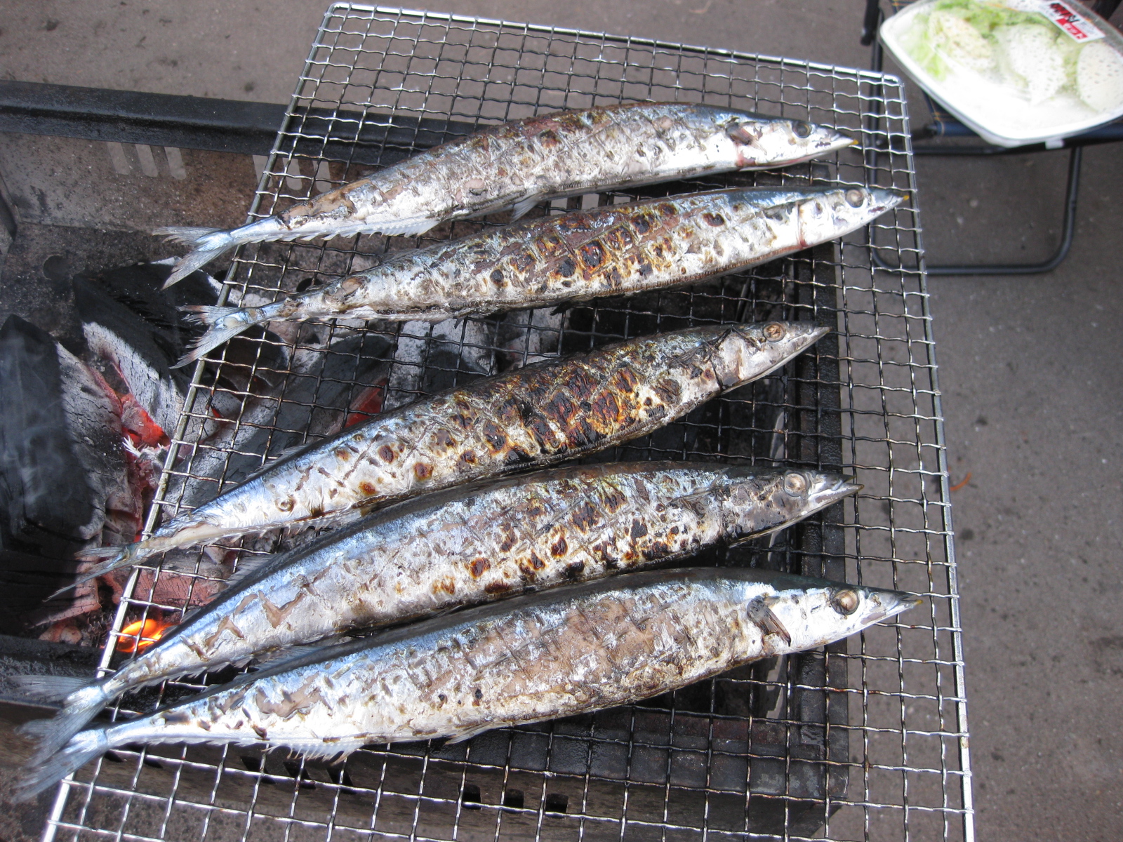 a bunch of fish are being cooked on a grill