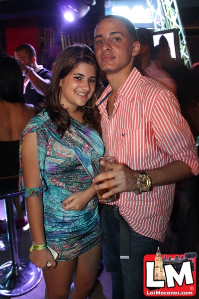man and woman pose for picture together at a nightclub