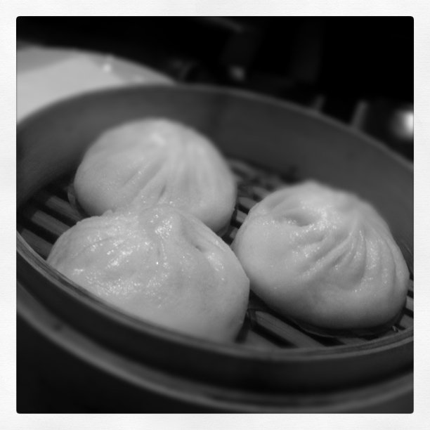 some chinese buns in a metal pan on top of a stove