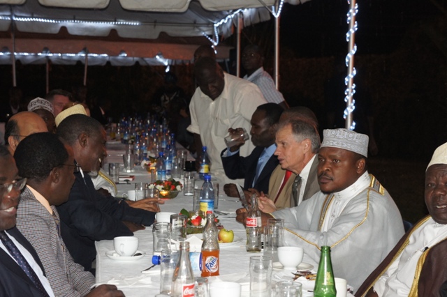 many men sit around a long table and eat food