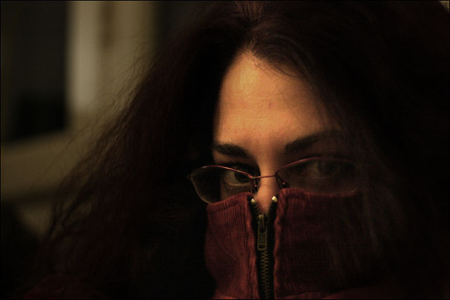a woman with glasses and red cloth covering her face