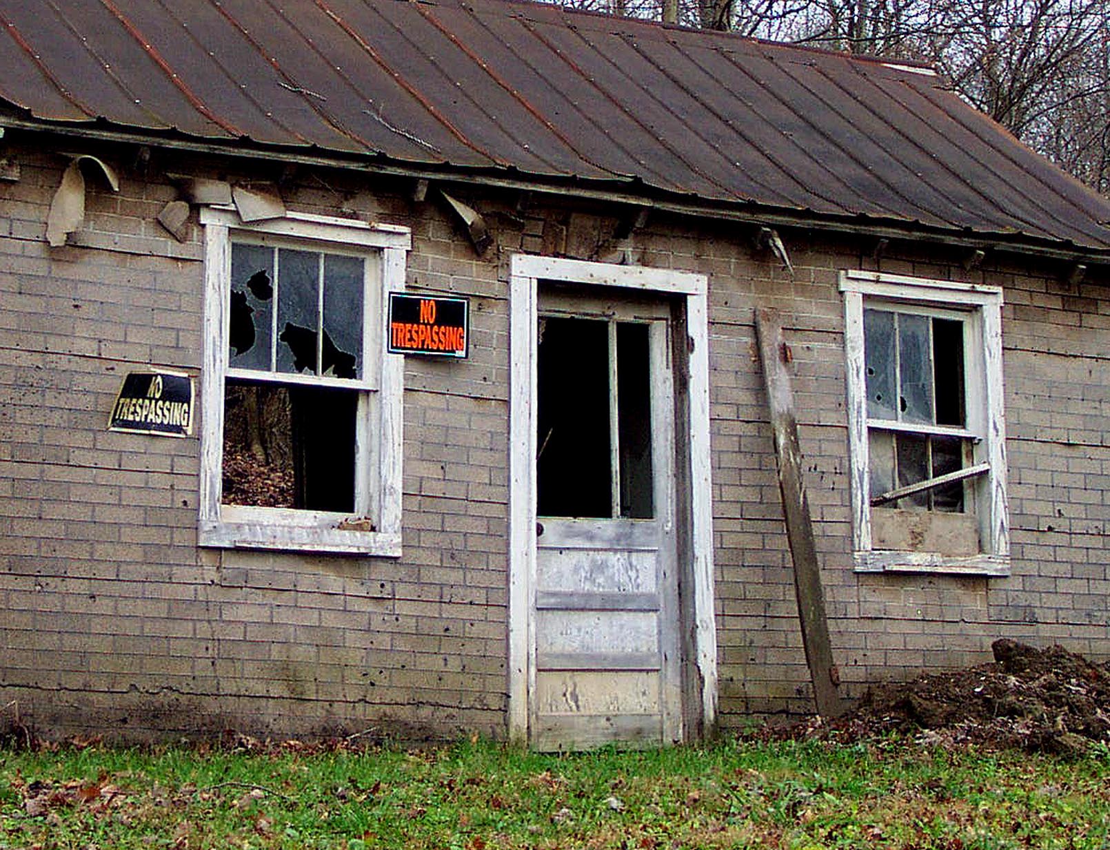 this is an old, run down garage building with a broken window