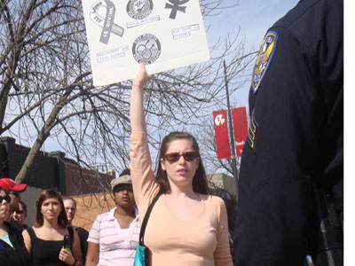 the woman holds a sign that reads love, hate and respect with several people behind her