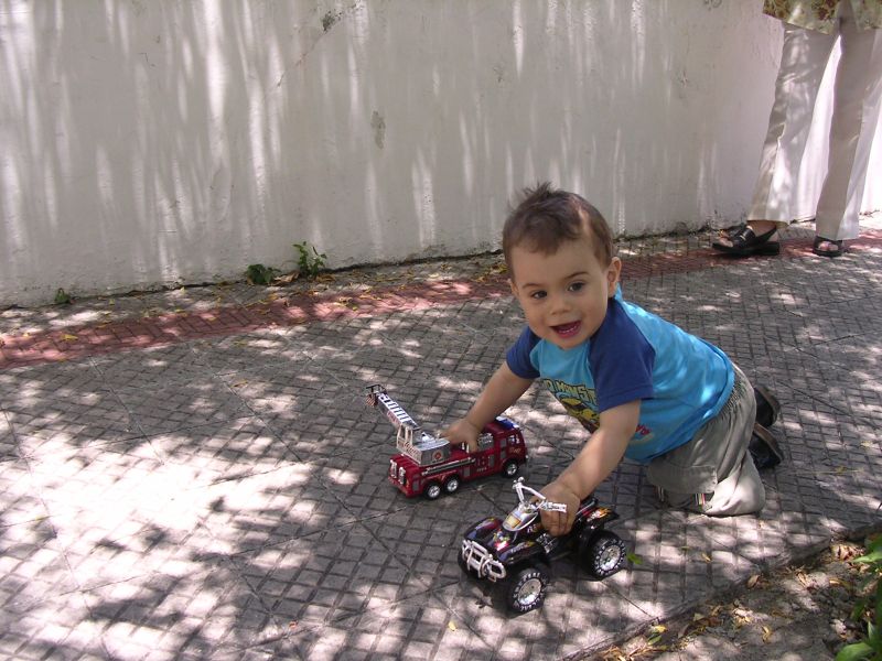 the little boy is playing with his toy cars