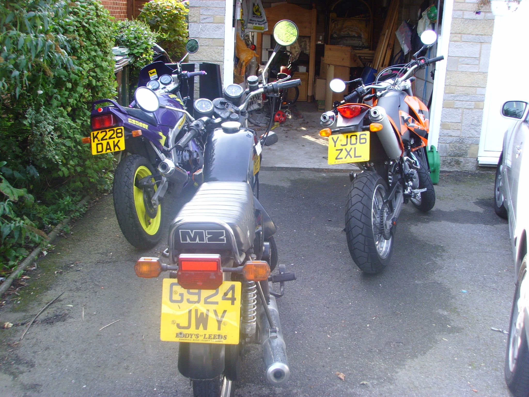 two motorcycles parked near one another in the street