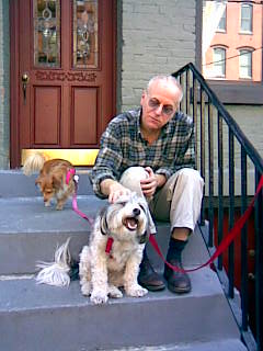 the man sits with his dog on the front steps