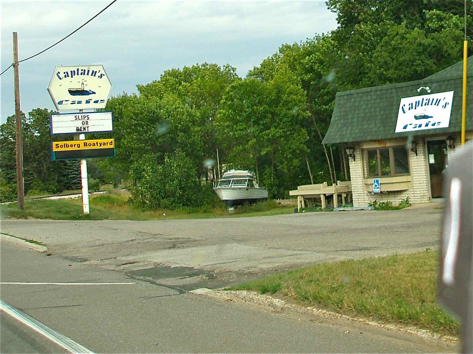 a sign at a road with the name of the business