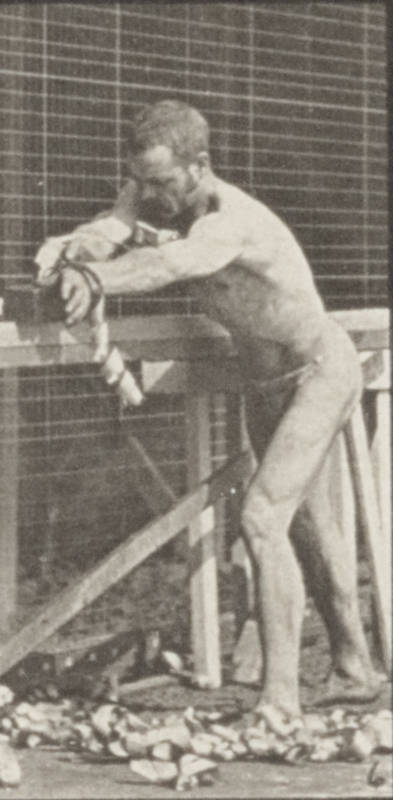 a black and white po of a man leaning on a fence