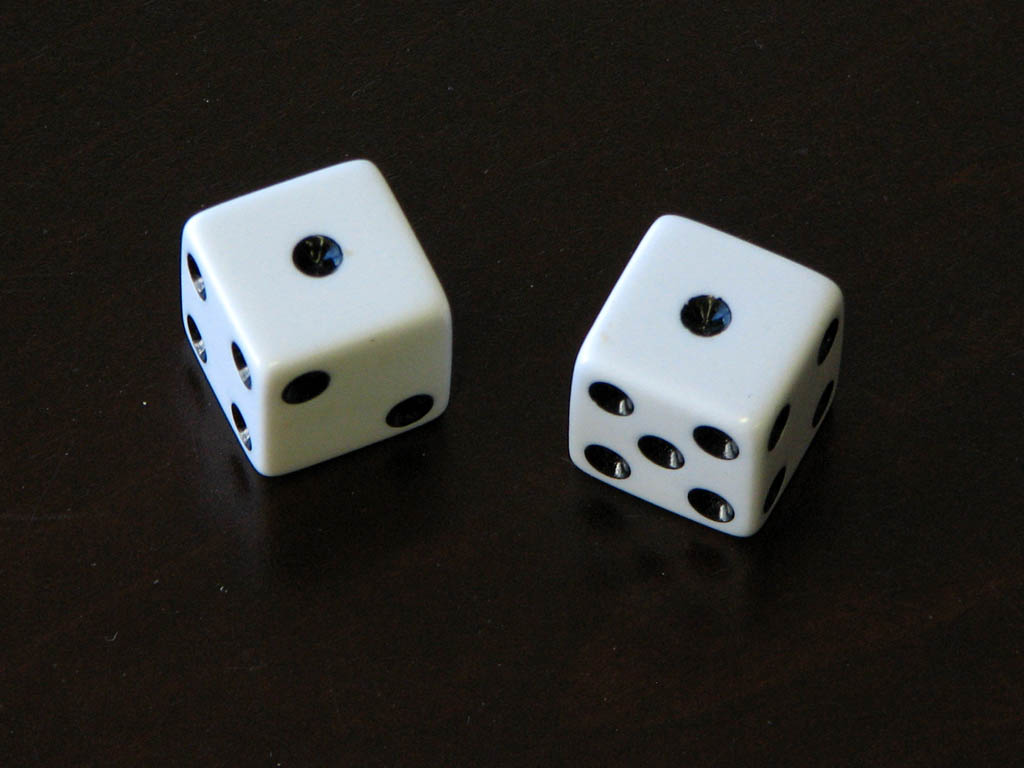 two white dice on a black table top