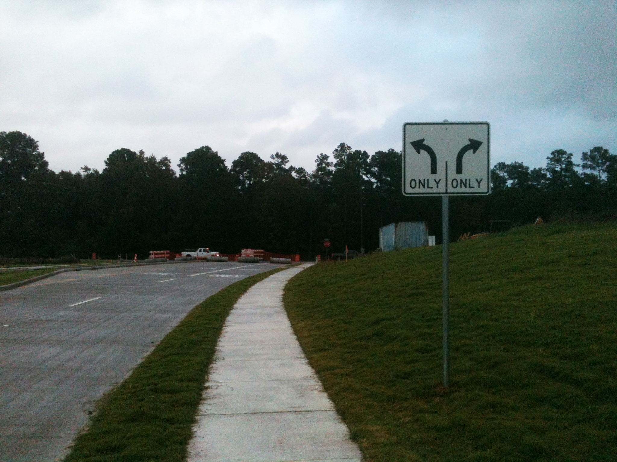 a long curve road with a single sign on it