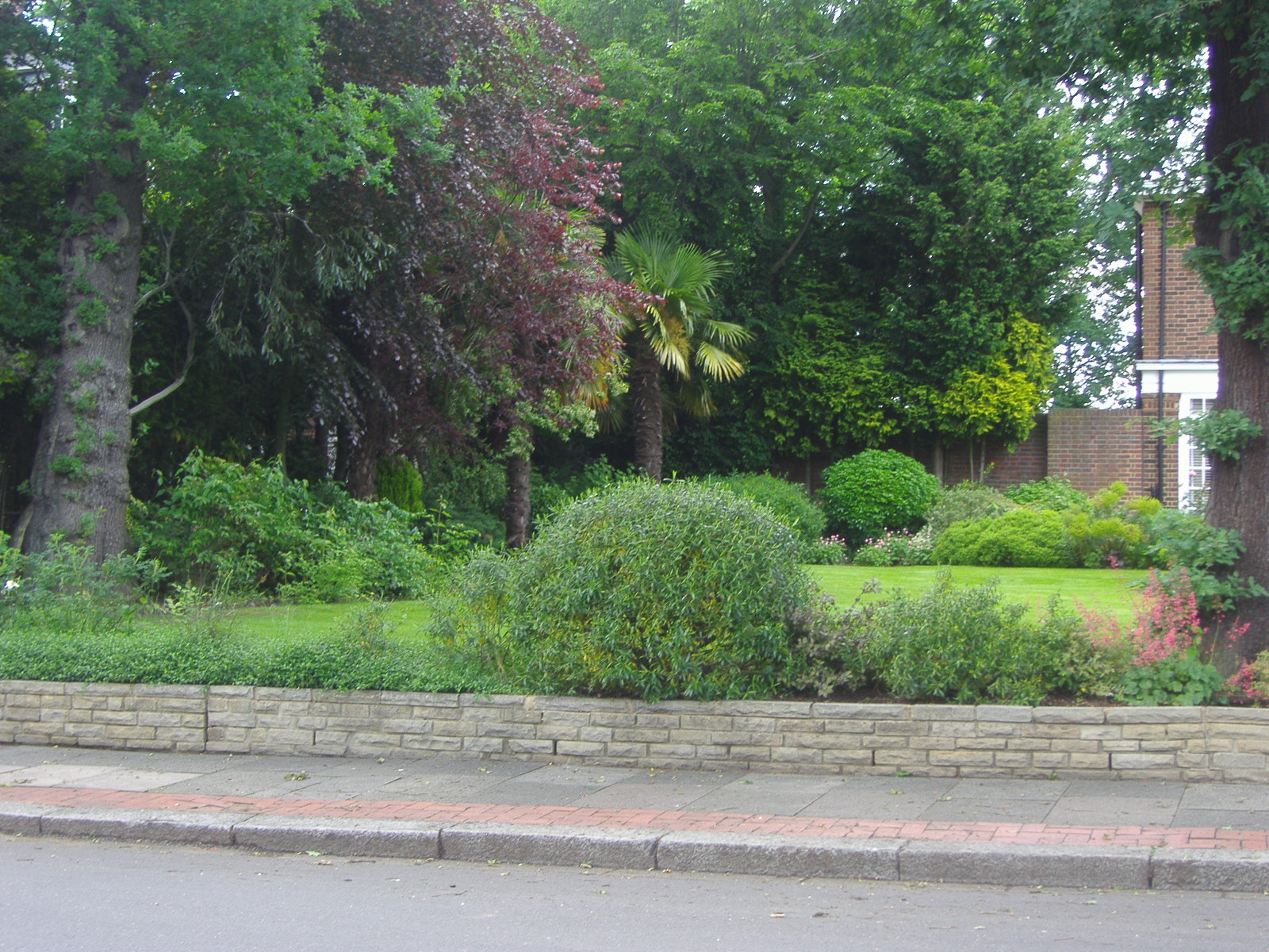 a lawn and trees are shown on the side of the road