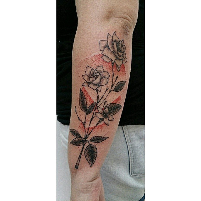 a man wearing a rose tattoo on his arm