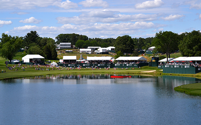 people on the course stand near the lake