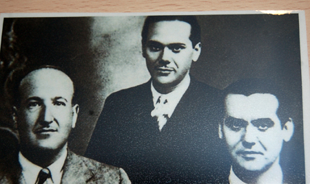 three men dressed in suits and ties posing for a po