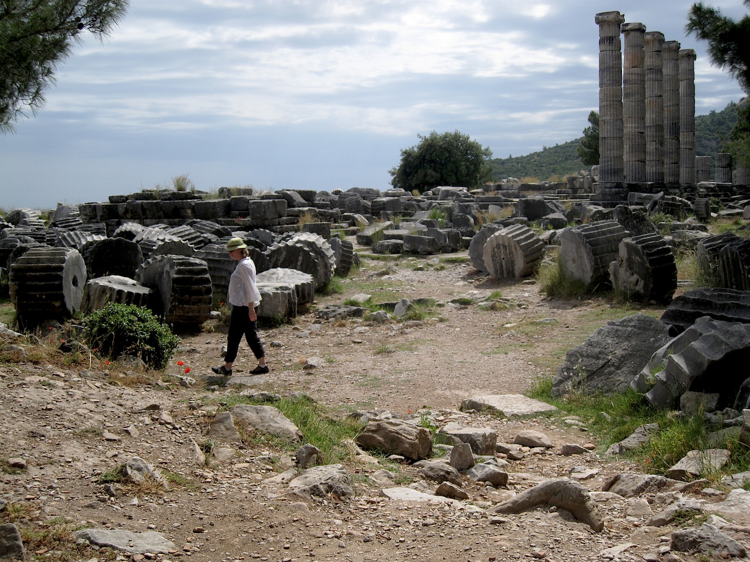 a man walking through a stone covered area with rocks and buildings