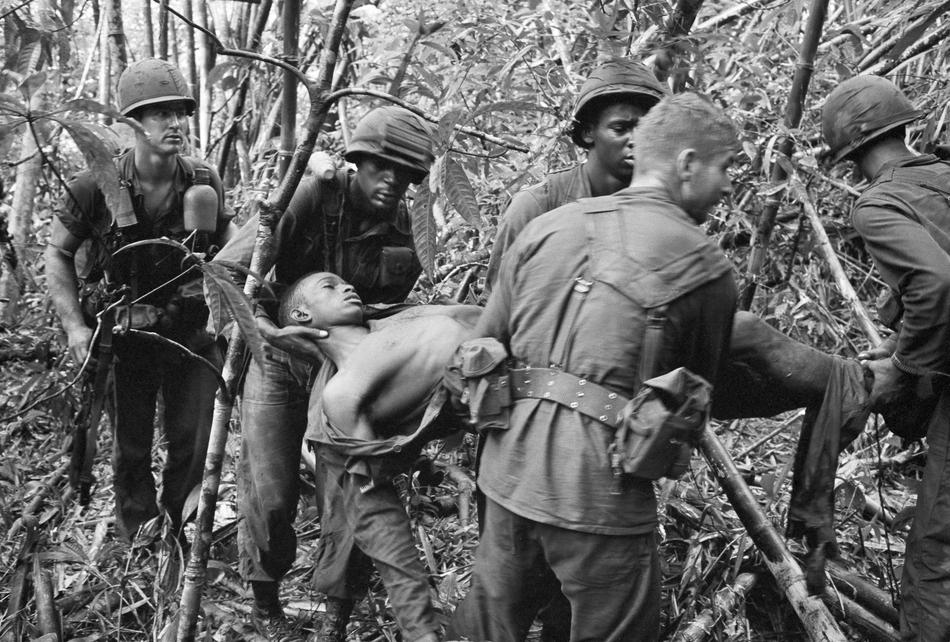 a black and white po of soldiers examining an injured boy