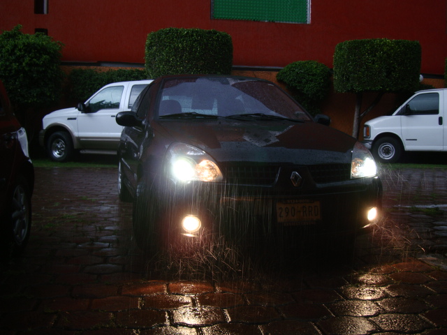 the lights of two parked cars in the rain