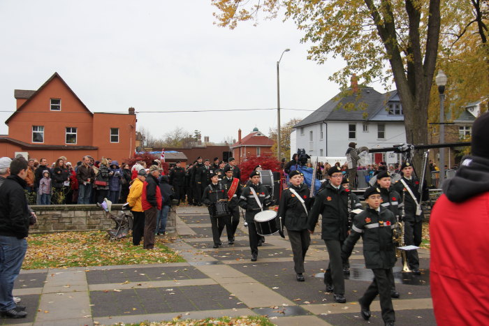 a band marching through a parade in a neighborhood
