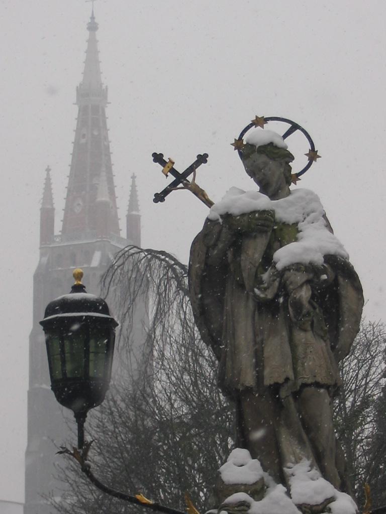 a statue of a man holding a cane in the snow