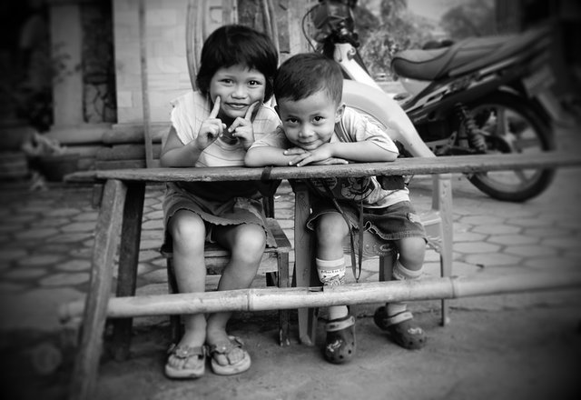two children sitting in front of a motorcycle
