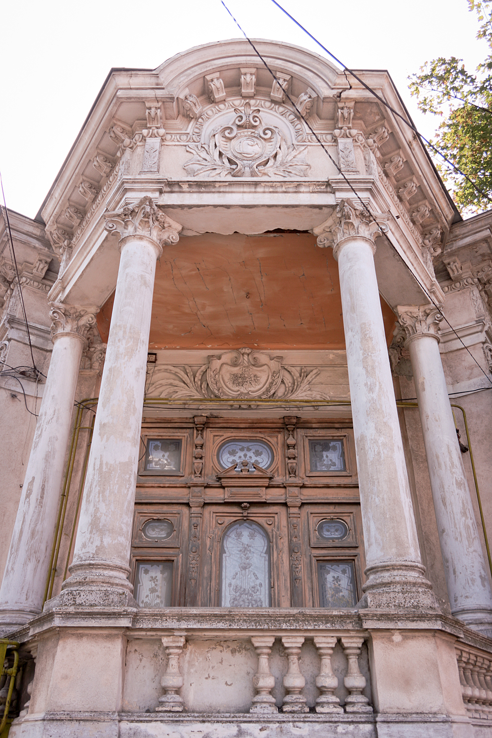 a large building with pillars with clocks on each side